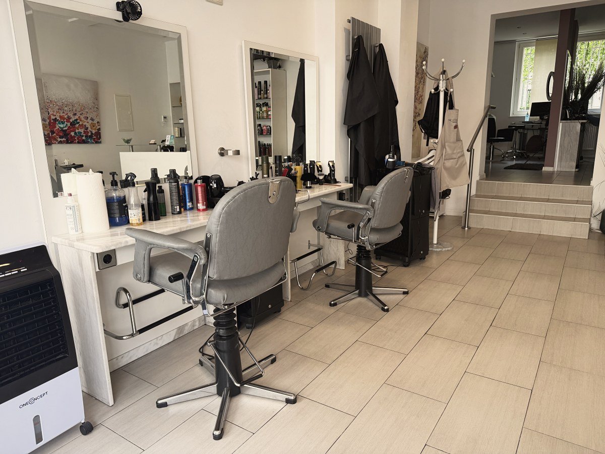 Weiterer Salonbereich mit Bedienplätzen und Aufgang
