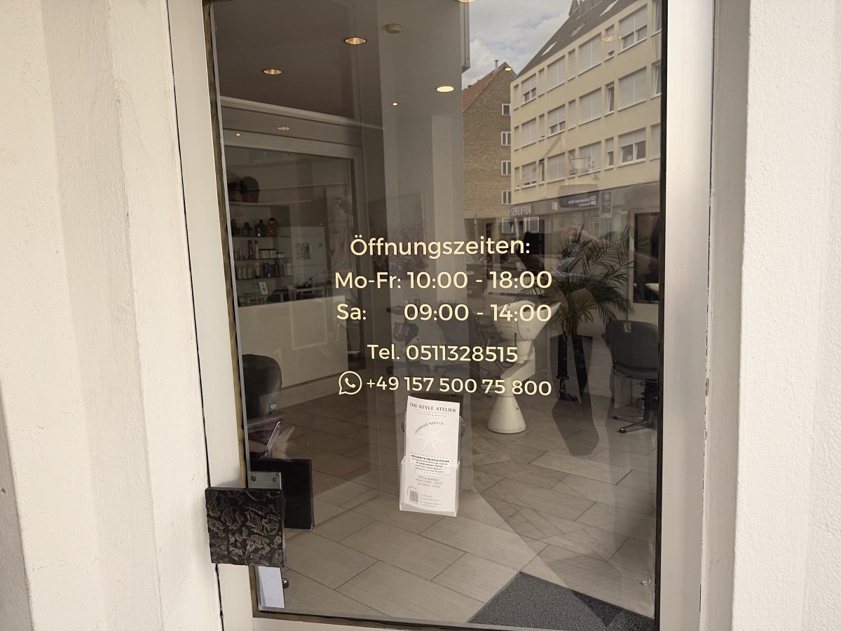 Eingangstür mit Öffnungszeiten und Telefonnummer